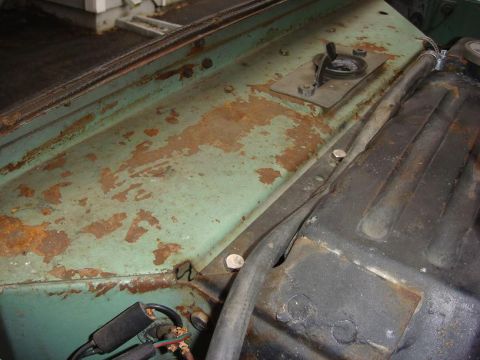 1967 Land Rover Land Rover - Close-up of a heavily rusted green metal panel, likely from a vehicle's engine bay.