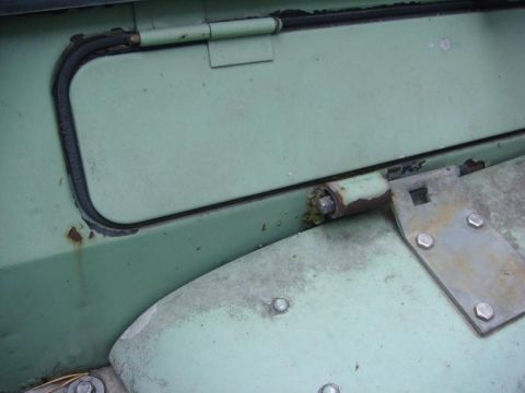 1967 Land Rover Land Rover - Close-up of a vehicle's exterior panel, showing wear and a hinge mechanism.