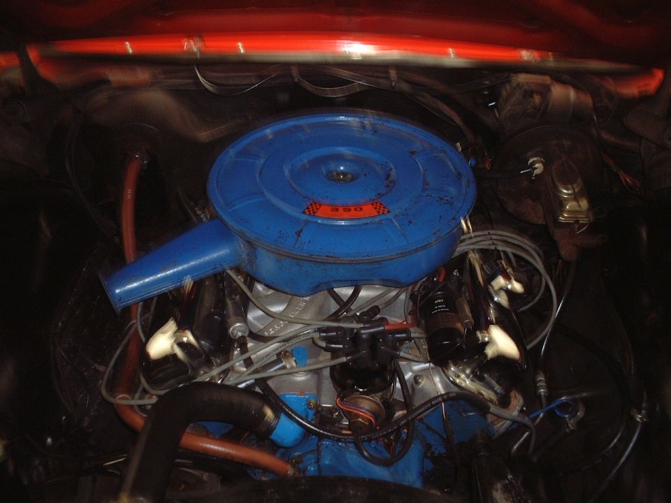 Engine bay with round blue air cleaner marked 390 on a V8