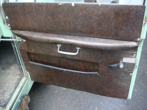 1967 Land Rover Land Rover - Close-up of a vehicle's interior door panel, showing wear and tear on the upholstery.