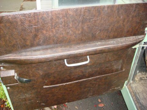 1967 Land Rover Land Rover - Close-up of a vintage car's interior door panel, showing wear and tear on the vinyl.