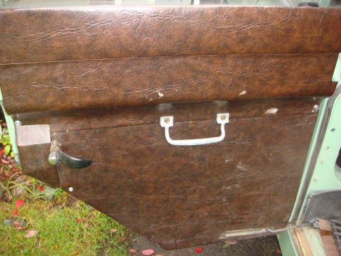 1967 Land Rover Land Rover - Close-up of the interior door panel of a 1967 Land Rover Land Rover, showing its textured brown vinyl and hardware.