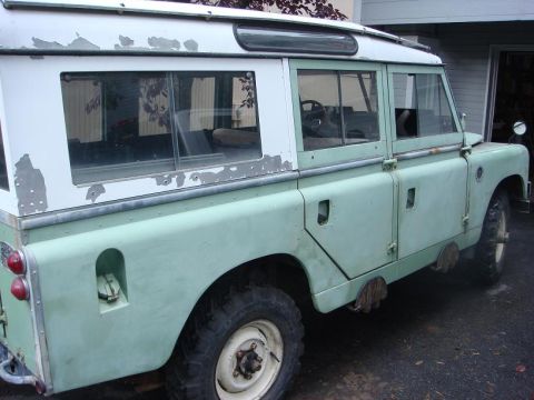 1967 Land Rover Land Rover - This 1967 Land Rover Series IIA is shown in a 3/4 front view, with visible peeling paint on its roof and body.