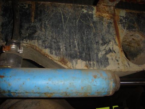 1967 Land Rover Land Rover - Underside view of a vehicle, showing a blue shock absorber and heavily rusted structural elements.