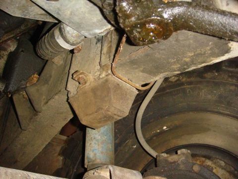 1967 Land Rover Land Rover - A close-up view of a vehicle's undercarriage reveals rusty metal components and a tire.