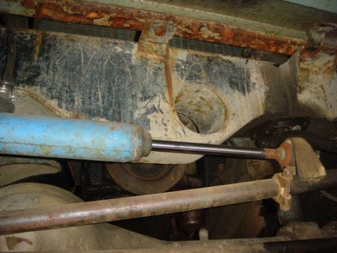 1967 Land Rover Land Rover - Close-up view of heavily corroded vehicle chassis components, including a shock absorber and steering linkage.