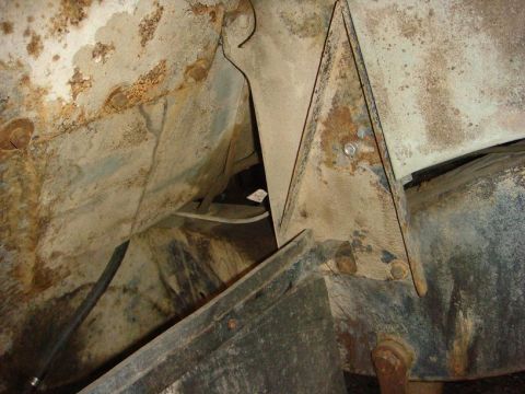 1967 Land Rover Land Rover - Close-up view of a heavily rusted chassis frame, showing a triangular support bracket and various mechanical components.