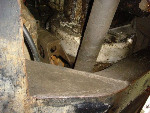 1967 Land Rover Land Rover - Close-up of the greasy undercarriage and drivetrain of a vehicle, showing various mechanical parts and a large pipe.