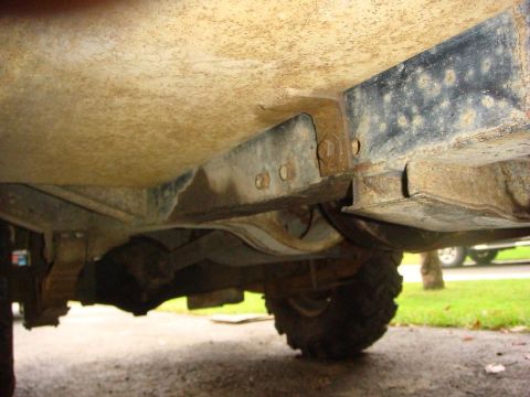 1967 Land Rover Land Rover - Close-up view of the undercarriage, showing the chassis and suspension of an off-road vehicle with signs of rust and wear.