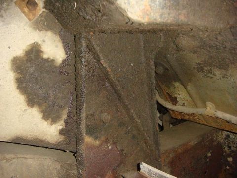 1967 Land Rover Land Rover - Undercarriage view showing heavily rusted frame sections and oil residue.