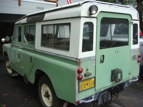 1967 Land Rover Land Rover - Rear view of a two-tone green and white Land Rover Series IIA, showing its distinctive rear door and taillights.