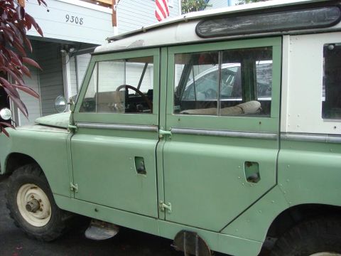 1967 Land Rover Land Rover - Side view of a green 1967 Land Rover Series IIA, showing its distinctive body style and windows.