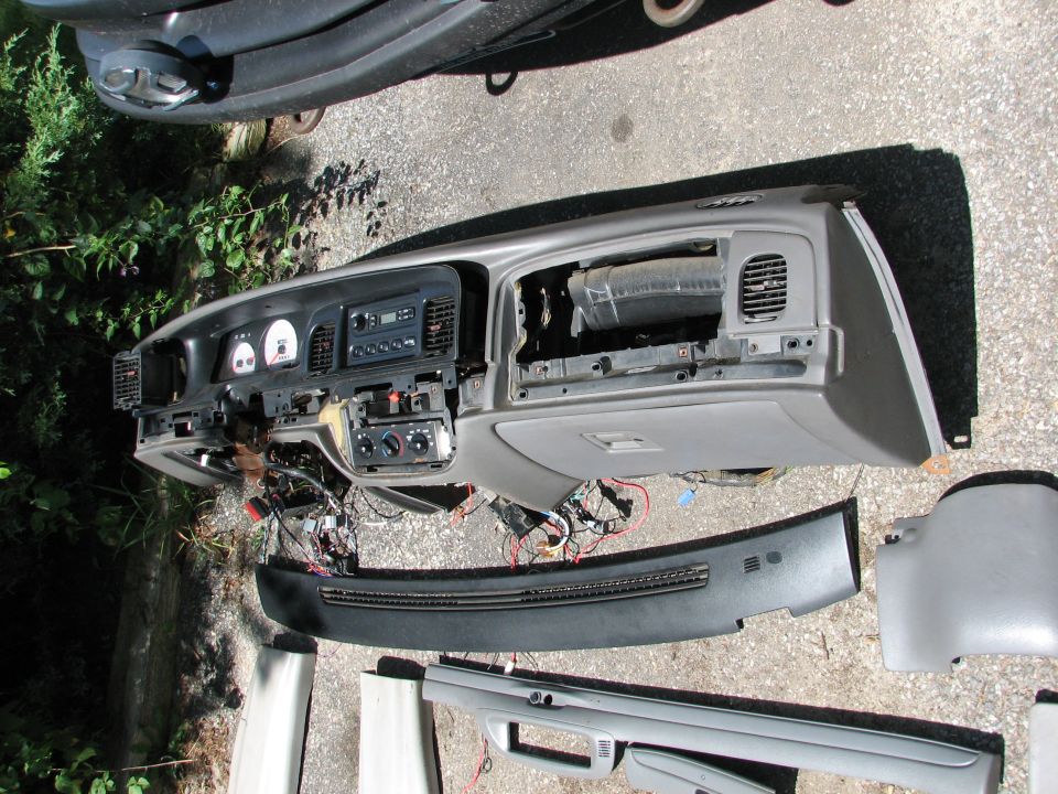Disassembled dashboard with wiring exposed, sitting on the ground