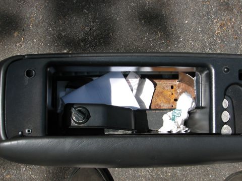 1999 Ford Crown Victoria - Interior view of an open glove box containing papers and a rusty metal bracket.