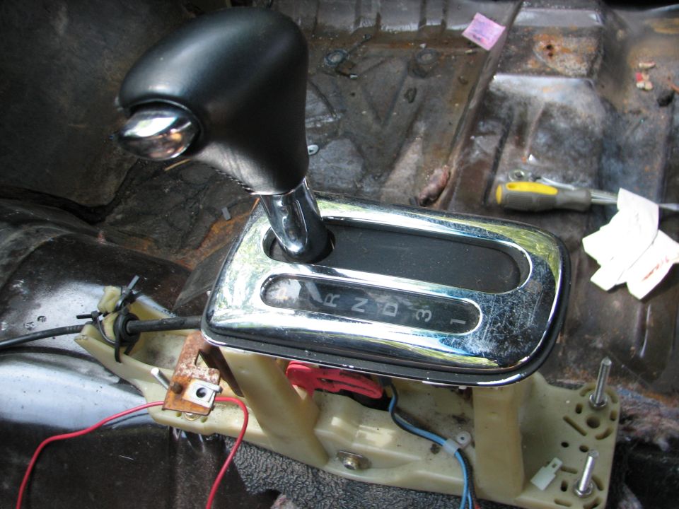 Automatic transmission shifter with P, R, N, D, 3, 1 markings. Interior of car is dirty