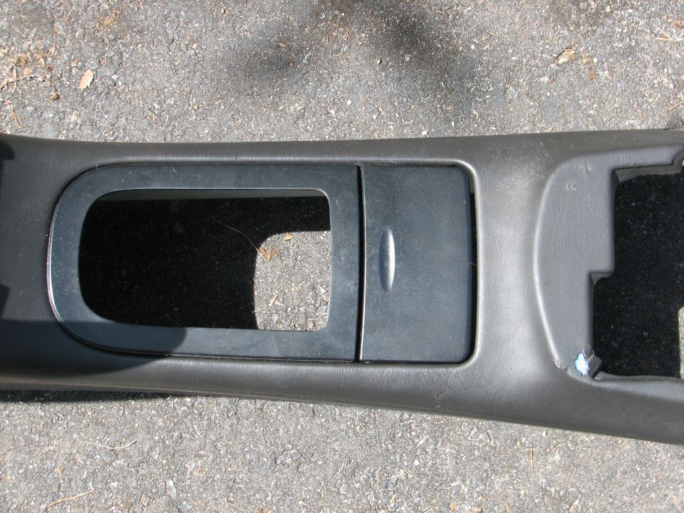 Car's center console trim piece with a flip-up compartment