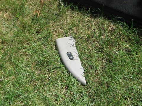 1999 Ford Crown Victoria - Interior door panel with window controls lying on grass.