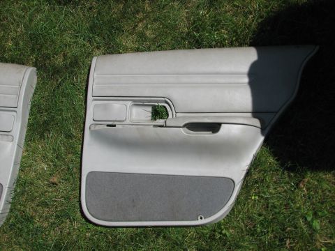 1999 Ford Crown Victoria - Car door panels are shown resting on a grassy surface, with one panel a dark gray fabric insert.