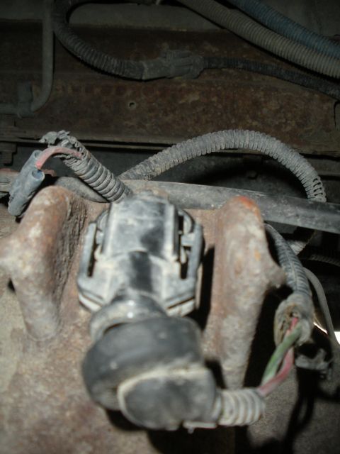 1996 Ford Bronco - Detail of a vehicle's wiring harness and connector, with visible rust on nearby components.