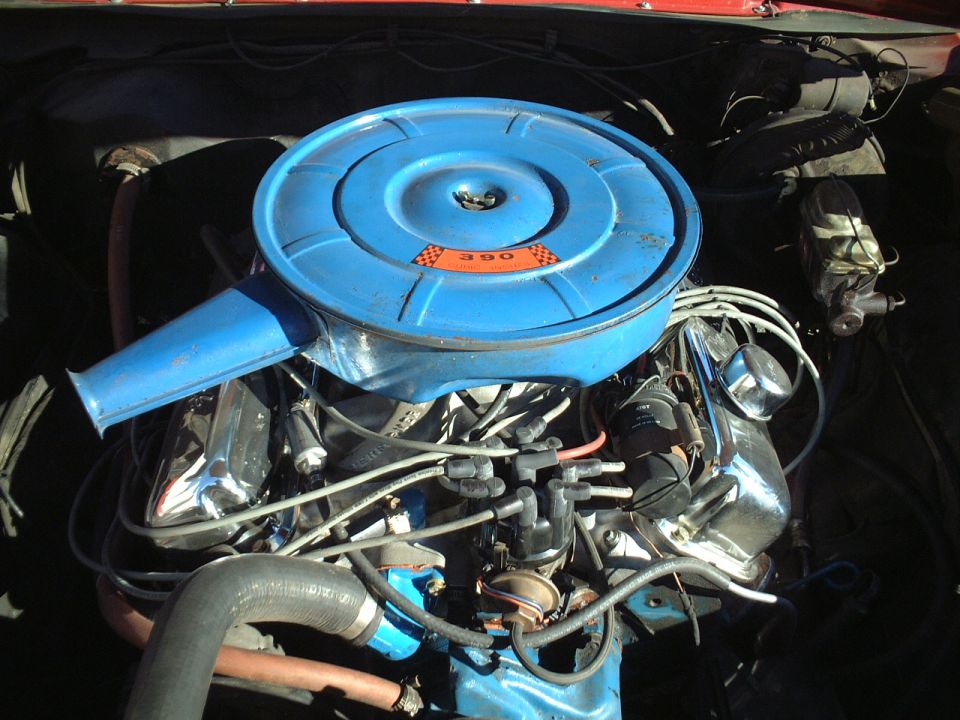 Blue round air cleaner labeled 390 atop a V8 engine with chrome valve covers