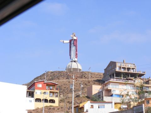 1986 Ford Bronco - A large statue of Jesus Christ stands atop a hill, with buildings and a clear blue sky in the background.