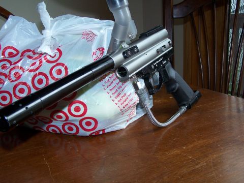 1986 Ford Bronco - A silver paintball gun with a black grip and barrel is placed on a table next to a Target shopping bag.