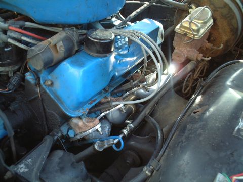 1967 Ford Galaxie - The engine bay shows a blue painted valve cover and various hoses and wires.