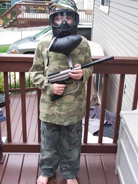 1986 Ford Bronco - A person dressed in paintball gear stands on a wooden deck holding a paintball marker.