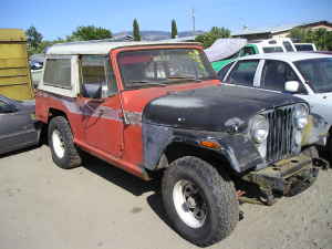 1991 Ford Bronco - This Jeep CJ-7 is parked next to another vehicle and a building.