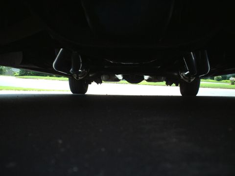 1967 Ford Galaxie - Underside view of a vehicle's dual exhaust system and rear wheels.
