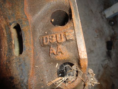 1989 Ford Bronco - This is a close-up view of a rusty metal casting with stamped identification numbers.