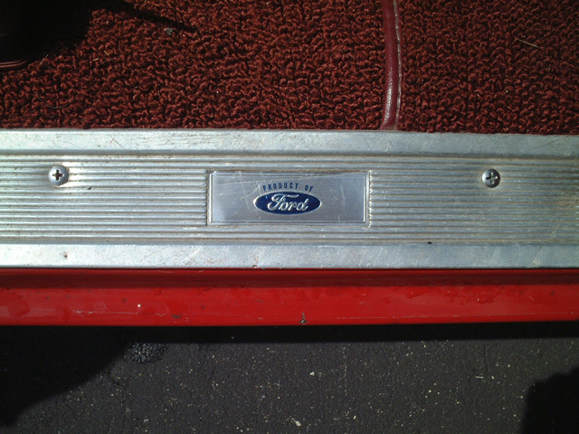 Ford door sill plate with blue 'Product of Ford' emblem, red carpet above
