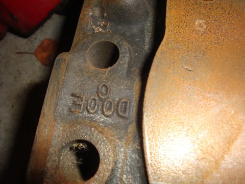 1989 Ford Bronco - A close-up view of a rusty metal component bearing the 'DODGE' casting mark.