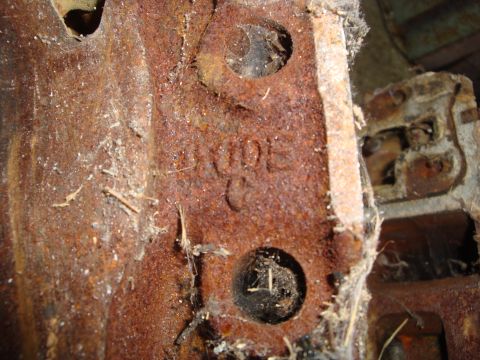 1989 Ford Bronco - A close-up view of a heavily rusted metal component, showing the embossed word 'LINCOLN'.