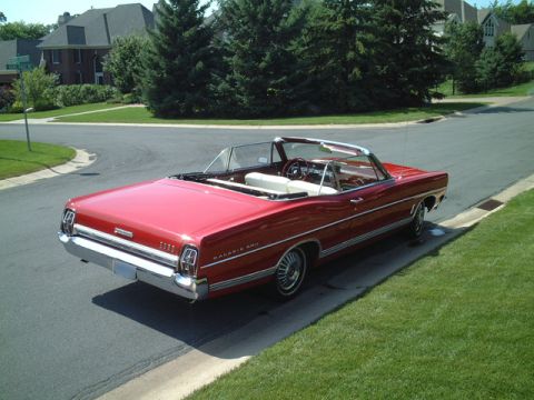 1967 Ford Galaxie - A red 1967 Ford Galaxie convertible is parked on the side of a road in a residential area.