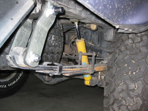 1990 Toyota Pickup/SR5 - Close-up of the rear suspension system, leaf springs and prominent yellow Bilstein shock absorbers.