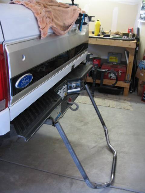 1995 Ford Bronco - The rear of a Ford Bronco shows a custom tire carrier attached to the bumper, with a towel draped over the tailgate.
