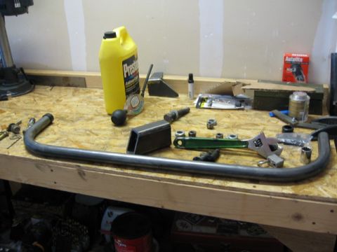 1995 Ford Bronco - Various parts and tools are laid out on a workbench, possibly for a vehicle modification project.