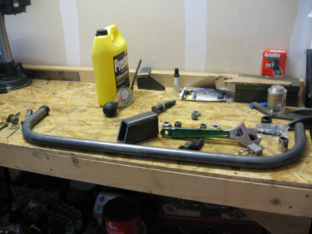 Fabrication parts, tools, and Prestone antifreeze on a workbench.