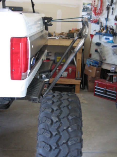 1995 Ford Bronco - Rear view of a 1995 Ford Bronco showing a custom tire carrier and large off-road tire.