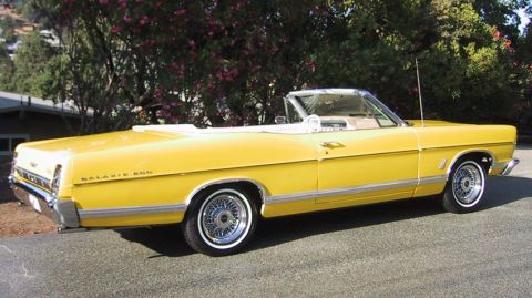 1967 Ford Galaxie - A bright yellow 1967 Ford Galaxie convertible with a white interior is parked outdoors.