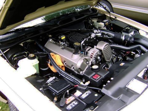 1996 Mercury Grand Marquis - The engine bay of a 1996 Mercury Grand Marquis, equipped with a supercharger, is visible under the hood.