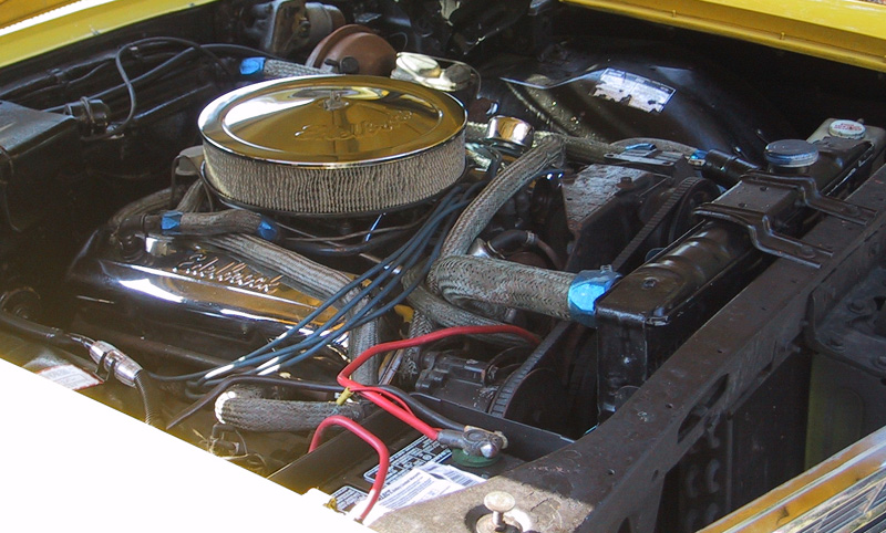 V8 engine bay with chrome Edelbrock air cleaner and red battery cables
