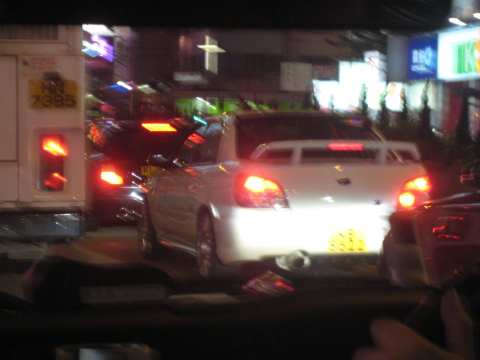 White 2007 Subaru Impreza WRX STI sedan in traffic at night, rear view