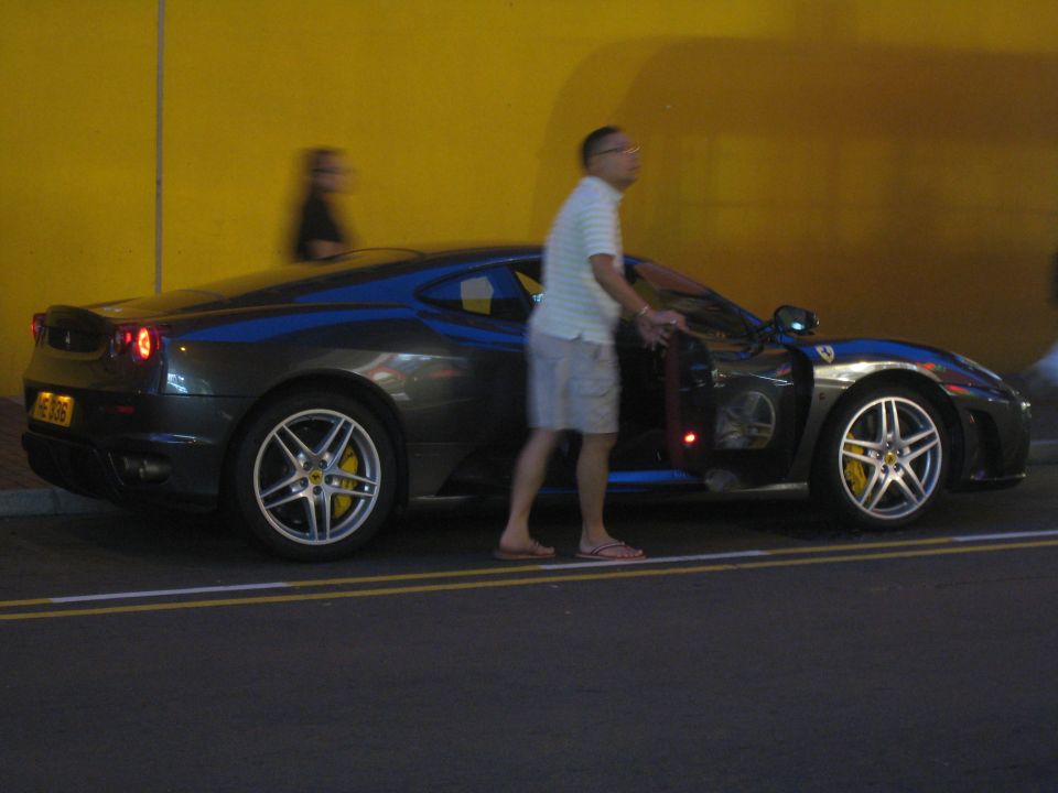 Dark gray Ferrari F430 coupe with yellow brake calipers, driver's door open