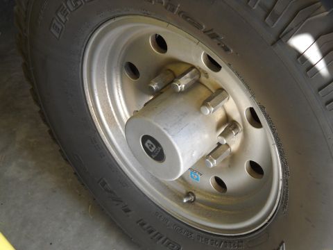 1996 Ford F-250 - A close-up view of a vehicle's wheel hub and tire, showing the Alcoa branding on the hubcap.