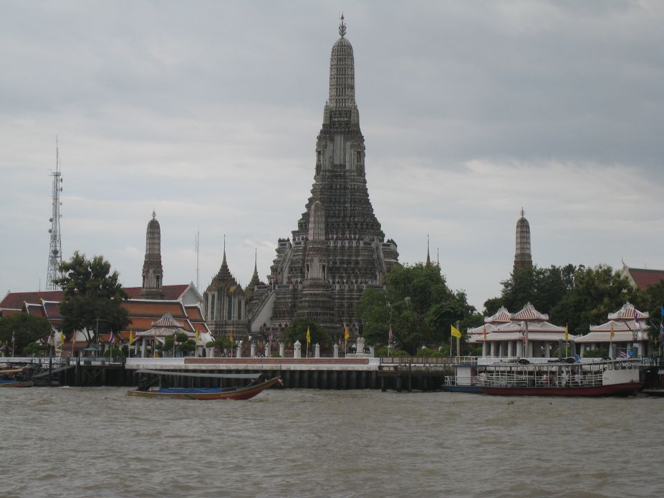 Wat Arun temple in Bangkok with boats on the river
