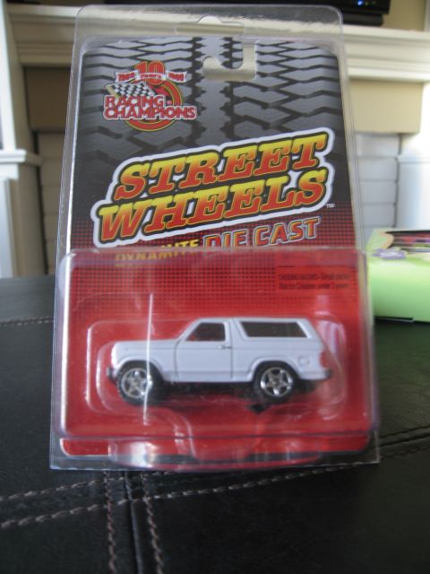 1986 Ford Bronco - A white diecast 1980s Ford Bronco is packaged for sale, showing its side profile.