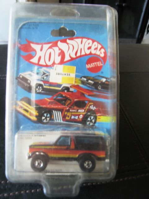 1986 Ford Bronco - Diecast toy Bronco in its original Hot Wheels packaging, multiple vehicles on the card.