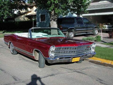 1967 Ford Galaxie - Red 1967 Ford Galaxie convertible with white interior, parked in front of a house with a dark SUV.